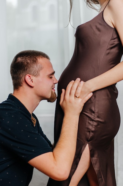 Ein Mann streichelt den Bauch eines schwangeren Mädchens