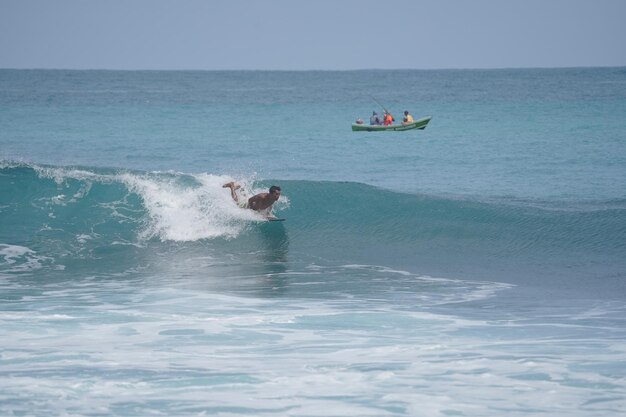 Ein Mann surft die Welle am Strand