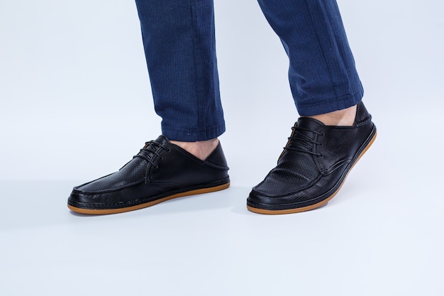 Ein Mann trägt klassische schwarze Schuhe aus Naturleder auf Spitze, Schuhe für Herren im Business-Stil