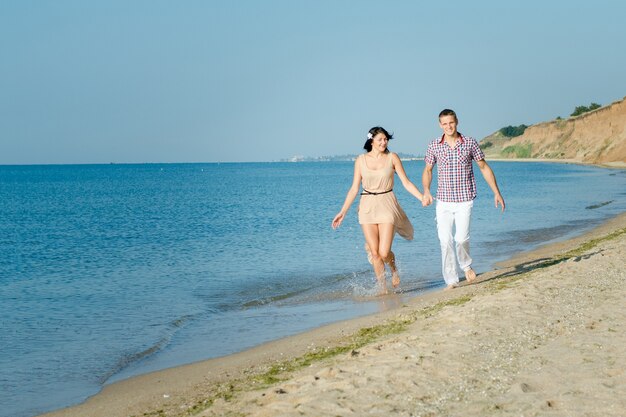 Ein Mann und ein Mädchen gehen am Meer entlang, schwimmen im Wasser