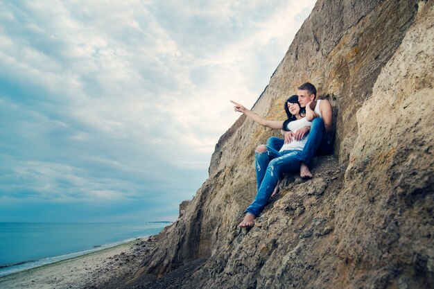 Ein Mann und ein Mädchen in Jeans und weißen T-Shirts am Meer