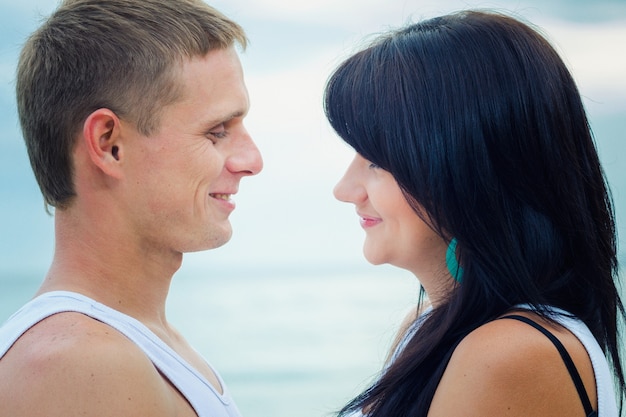 Ein Mann und ein Mädchen in Jeans und weißen T-Shirts am Meer