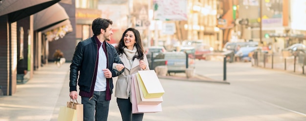 Ein Mann und eine Frau gehen auf der Straße mit Einkaufstaschen und unterhalten sich