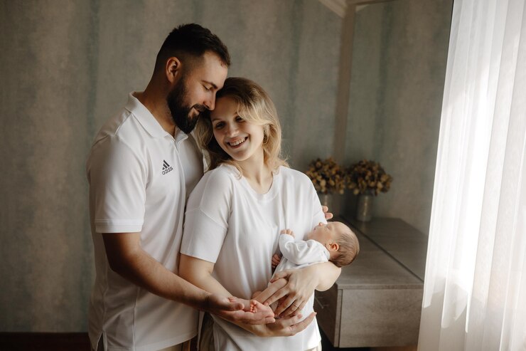 Foto ein mann und eine frau halten ein baby und lächeln