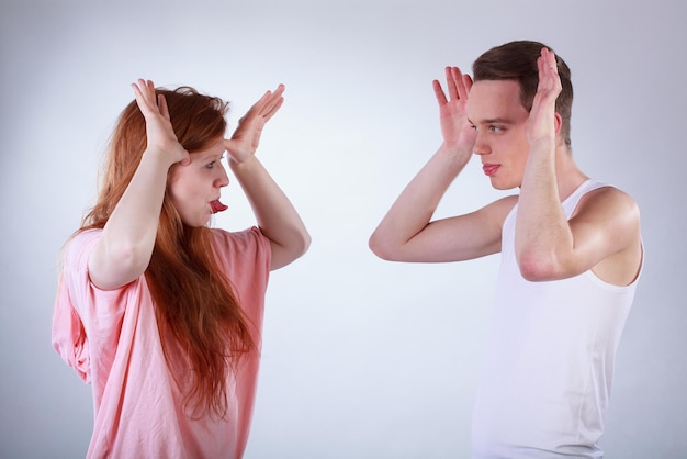 Ein Mann und eine Frau schauen sich mit erhobenen Händen an.