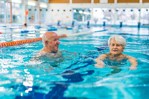 Ein Mann und eine Frau schwimmen in einem Pool mit einem Schild, auf dem „das Wort“ steht.