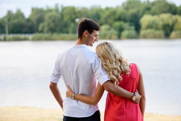 Ein Mann und eine verliebte Frau gehen in den Park und umarmen sich.