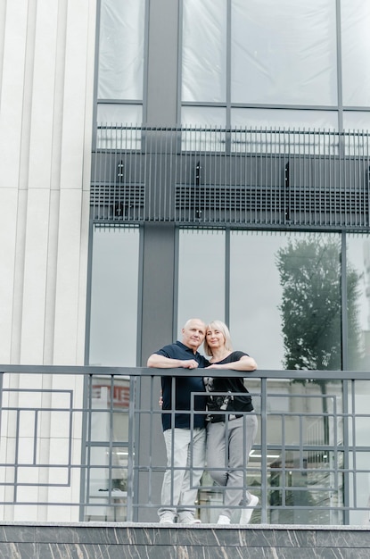 Foto ein mann und seine frau in schwarzen t-shirts umarmen sich in der stadt