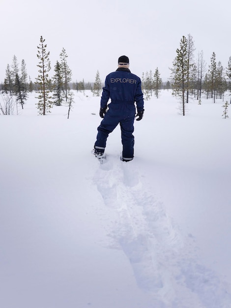 Ein Mann von hinten im Schneeoverall in der Lappland-Tundra auf jungfräulichem Schnee