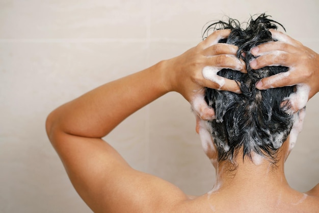 Ein Mann wäscht seine Haare mit Shampoo