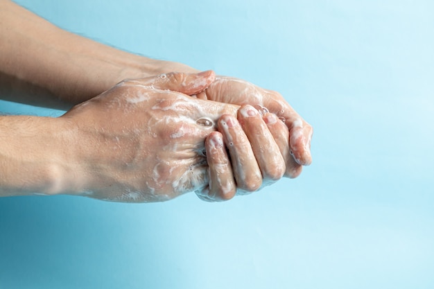 Ein Mann wäscht seine Hände mit Seife und verwendet ein Antiseptikum, um seine Hände zu reinigen und zu desinfizieren. Virusprävention, Coronovirus. Hygienekonzept Hand Detail.