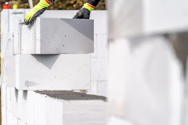 Ein Maurer baut die Mauer eines Hauses mit Ziegeln