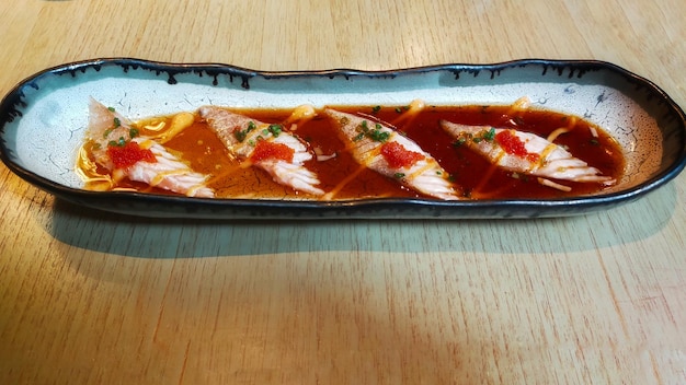 Ein Menü aus der Sushi-Bar namens „Aburi Salmon Belly Carpaccio“ ist ein halb gekochter Lachs mit einer sehr weichen Spezialsauce
