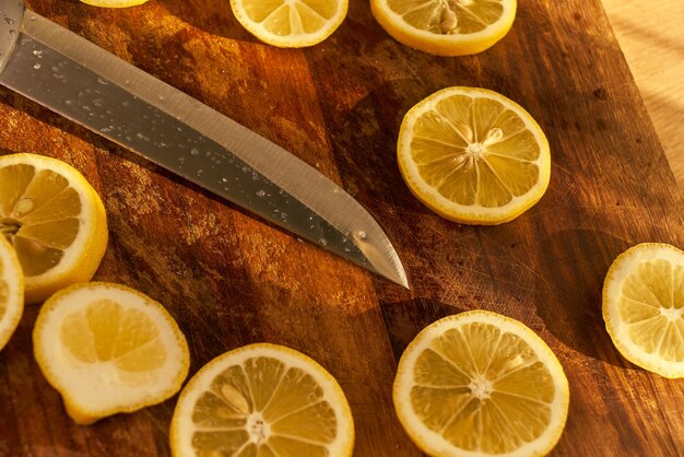 Ein Messer liegt auf einem Schneidebrett mit Zitronen darauf.