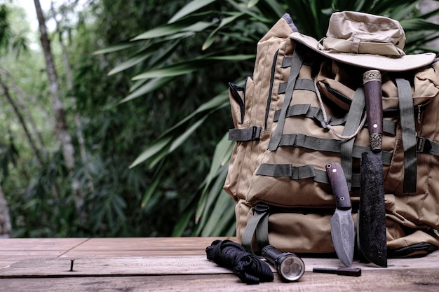 Ein Messer mit Überlebensausrüstung im Wald auf einem alten Holzboden