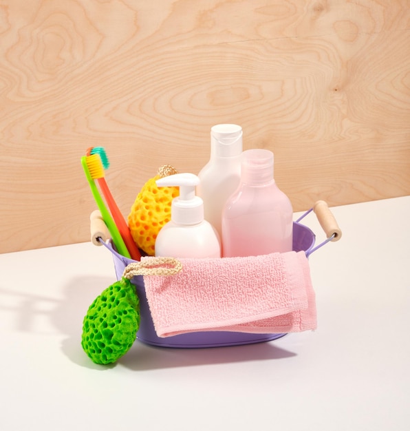 Ein metallisch-violettes Waschbecken mit Duschgels und Shampoos, handtuchfarbenen Zahnbürsten und Duschschwämmen