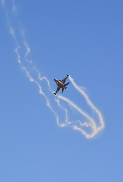 Ein militärischer Kampfjet fliegt am blauen Himmel