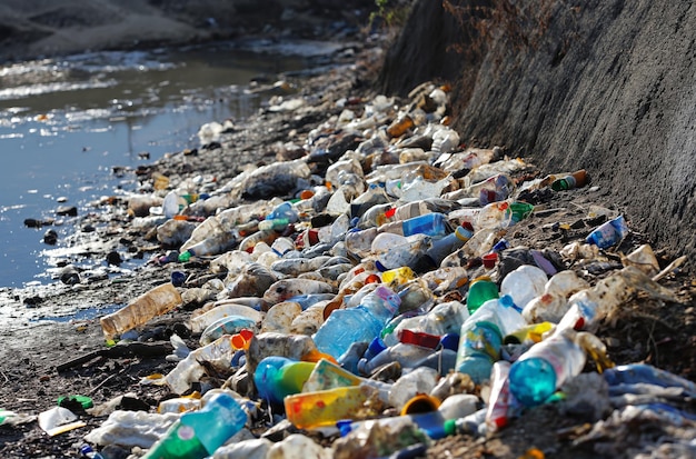 Ein mit Müll gefüllter Strand neben einem Gewässer