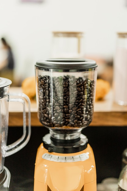 Foto ein mixer mit kaffeebohnen drauf und ein glaskrug mit dem wort kaffee drauf.