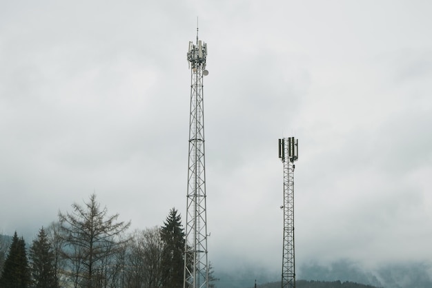 Ein Mobilfunkmast auf einem Feld mit Bäumen im Hintergrund