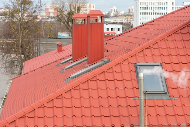 Ein moderner Neubau mit rotem Ziegeldach Lüftungsrohre ragen aus dem neu renovierten Dach Ein Bürogebäude für die Geschäftsabwicklung