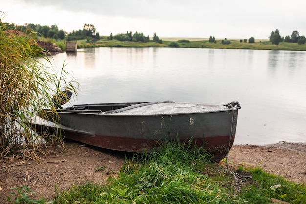 Ein Motorboot wird abends bei Sonnenuntergang oder früh morgens am Ufer eines Sees oder Flusses geparkt