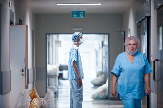 Ein müder Chirurg verlässt den Operationssaal nach der Operation ein müder Arzt arbeitet hart hart an der Arbeit