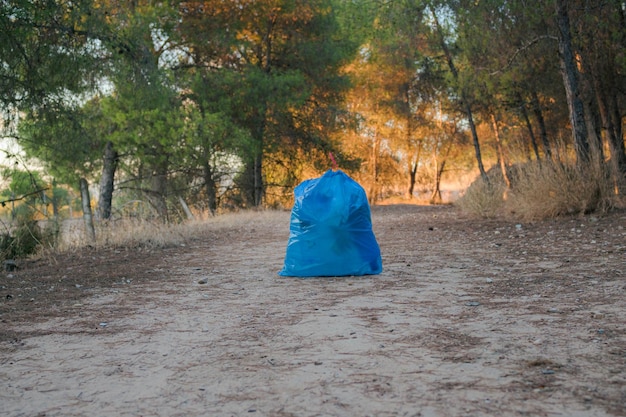 Ein Müllsack voller Plastik in einem Wald