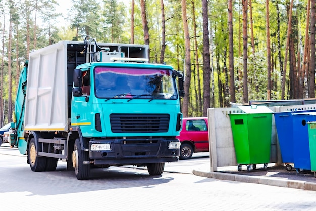 Ein Müllwagen holt Müll in einem Wohngebiet ab Verladen von Müll in Containern ins Auto Getrennte Sammlung und Entsorgung von Müll Müllfahrzeug