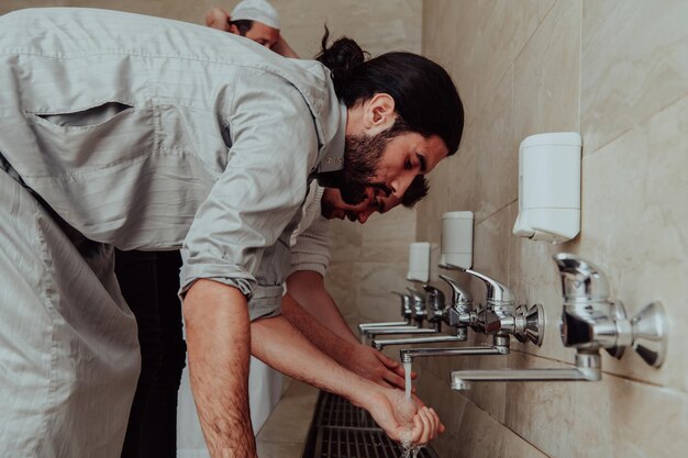 Foto ein muslim, der die waschung durchführt. rituelle religiöse reinigung von muslimen vor dem gebet. der prozess der reinigung des körpers vor dem gebet.