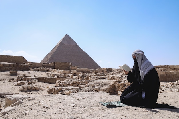 Ein Muslim mit Robenkleidung, der in der Wüste betet