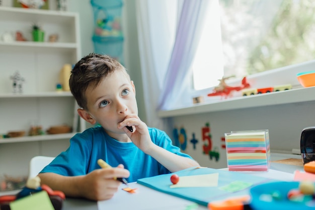 Ein nachdenklicher Junge sitzt am Tisch