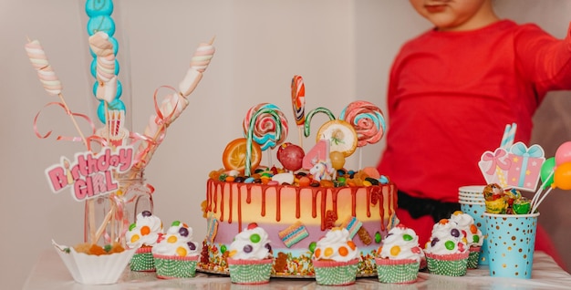 Ein Nahaufnahmefoto einer Geburtstagstorte und eines Muffins auf einem dekorierten Tisch