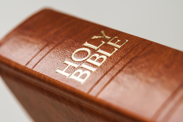Ein Nahaufnahmefoto eines heiligen Bibelbuches des Ledereinbandes mit weißem Hintergrund
