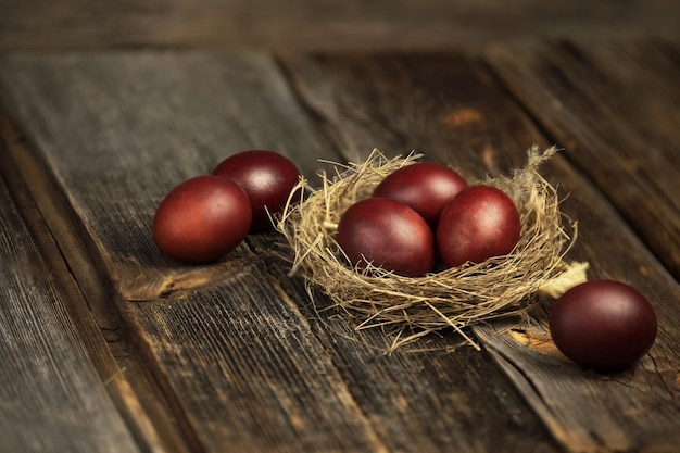 Ein natürliches Nest mit Eiern auf dunklem Holzhintergrund