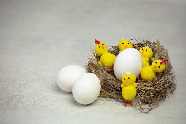 Ein natürliches Nest mit Eiern und dekorativen Hühnern im Inneren auf weißem Hintergrund