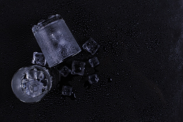 Ein nebliges Glas und ein Eis liegt auf einem schwarzen Hintergrund