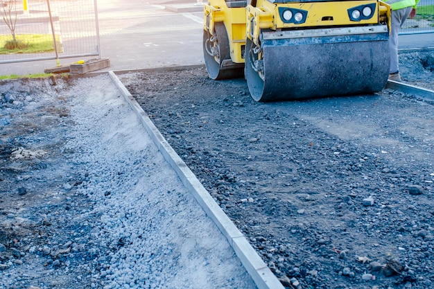 Ein neuer Fußweg ist im Bau, während die Bauarbeiter Steine ebnen und verdichten