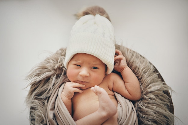 Ein neugeborenes Baby in eine Decke gewickelt mit einem warmen Hut auf dem Kopf. die Kindheit, Gesundheit, IVF.