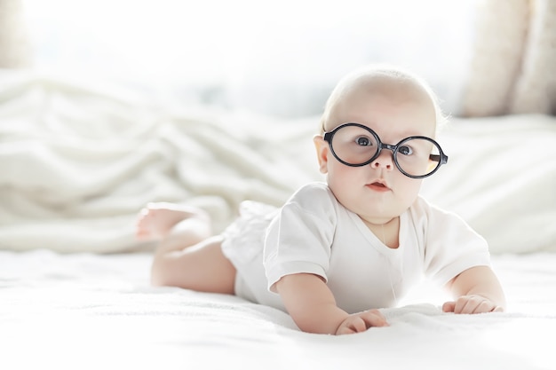 Ein neugeborenes Baby liegt auf einem weichen Bett. Emotionserziehung von Kindern.