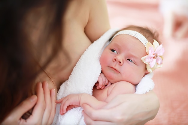 Ein neugeborenes Baby liegt in den Armen seiner Mutter. Ein schönes Baby von europäischem Aussehen schläft.