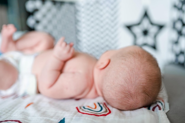 Ein neugeborenes Baby liegt mit dem Rücken zur Kamera und betrachtet die entstehenden Kontrastbilder