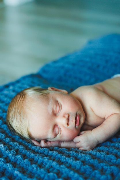 Ein Neugeborenes schläft auf einer gestrickten Decke Eine Decke aus natürlichem Stoff für ein Neugeborenes