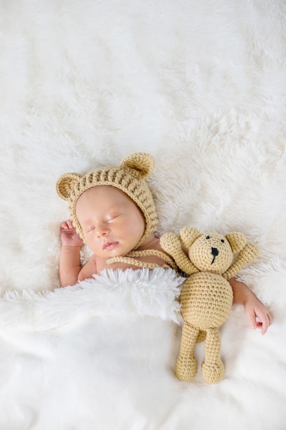 Ein Neugeborenes schläft mit einem Teddybär