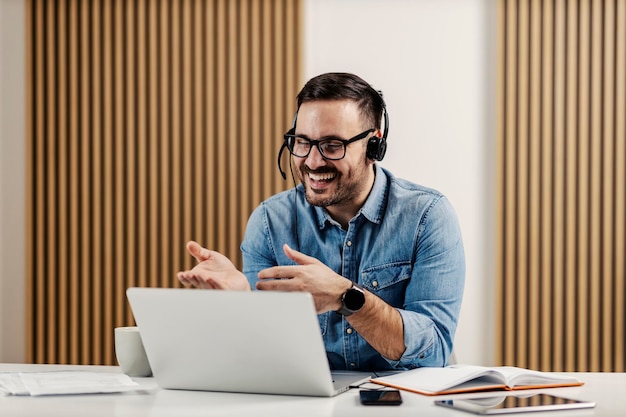 Ein Online-Lehrer eines Tutors, der in seinem Heimbüro Online-Unterricht auf dem Laptop gibt