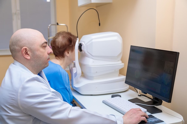 Ein Ophthalmologe überprüft mit einem modernen Gerät das Augenlicht einer erwachsenen Frau