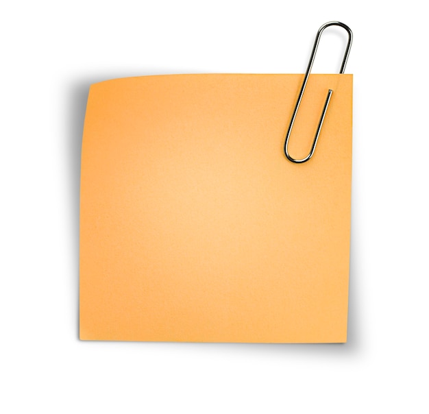 Ein orangefarbenes Blatt Papier auf einer Büroklammer auf einem isolierten weißen Hintergrund