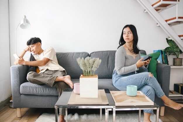Ein Paar, das nicht miteinander spricht und auf dem Smartphone tastet