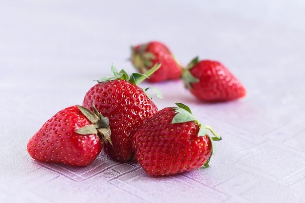 Ein paar Erdbeeren auf einer weißen Tischdecke