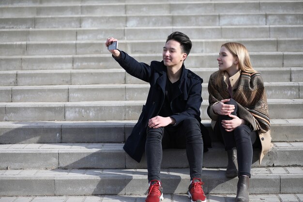 Ein paar Freunde sitzen auf den Stufen in der Stadt